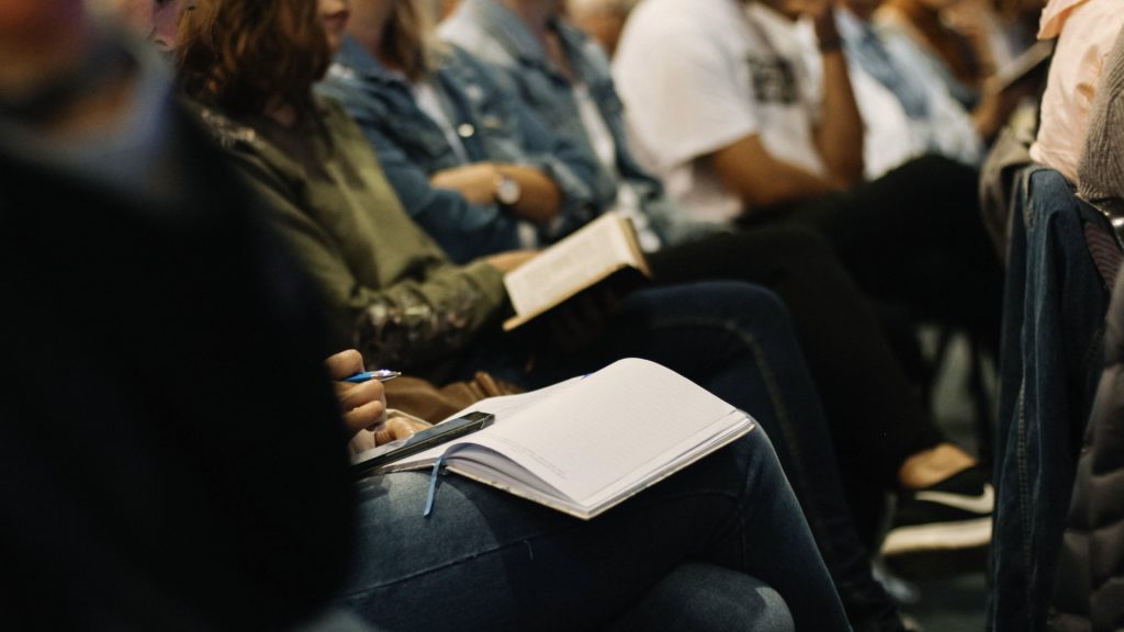 People sitting in chairs with bibles in their laps.